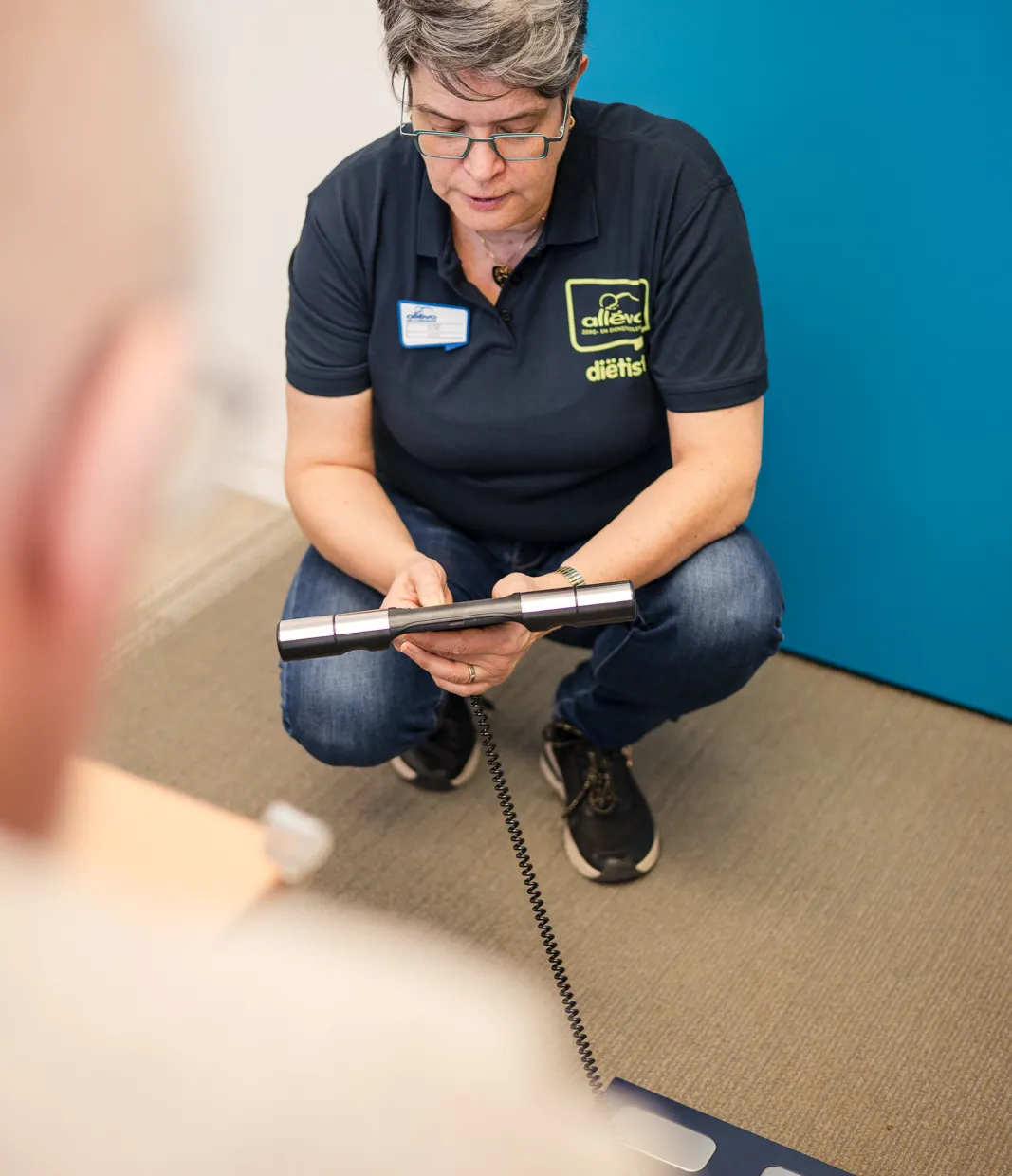 dietiste legt een meting uit aan een client