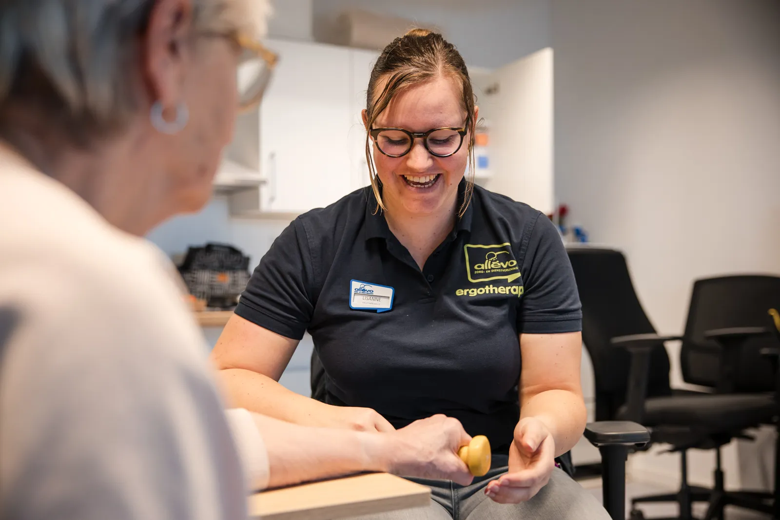 ergotherapeute voert handoefening uit met client ergotherapie