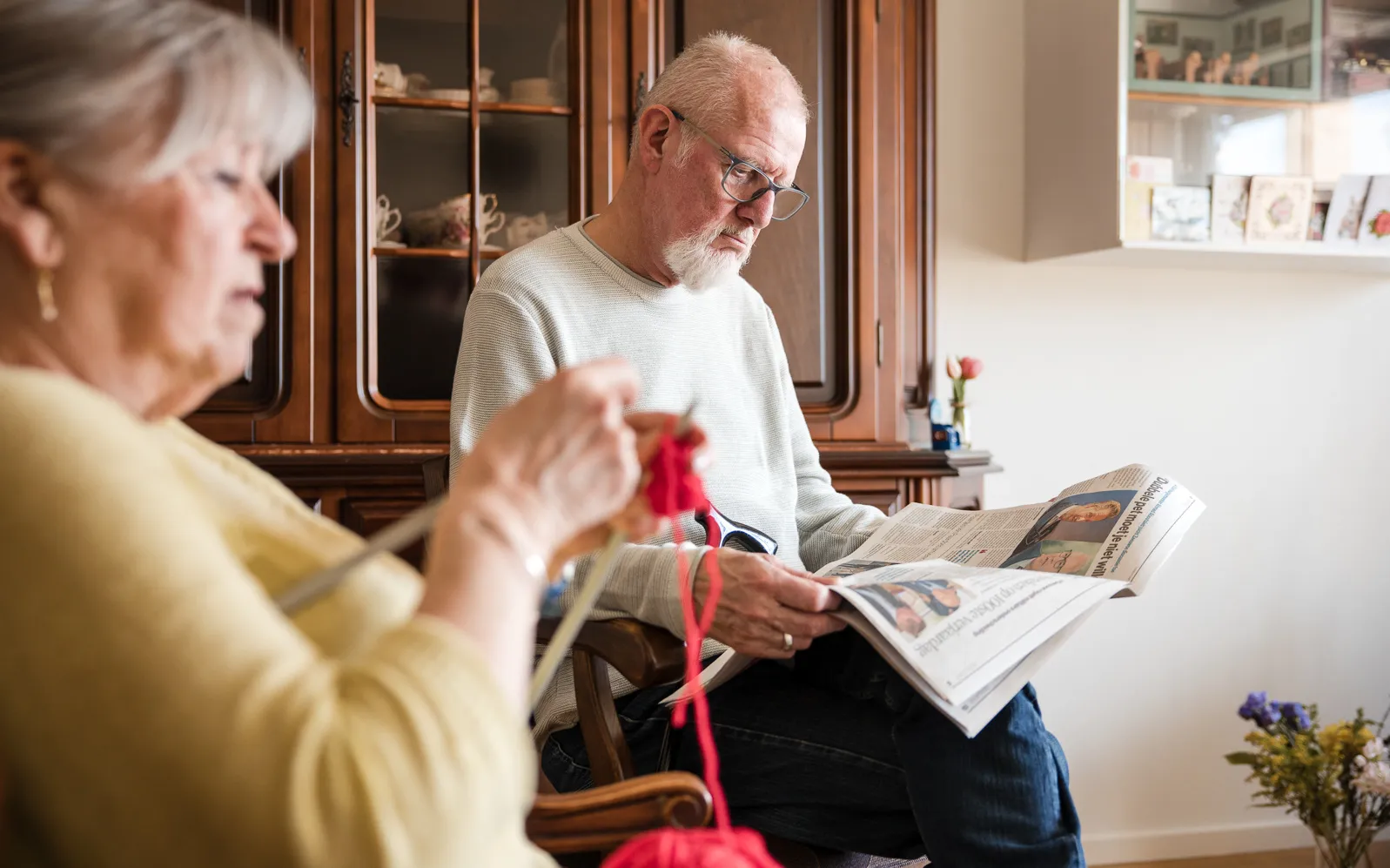 man en vrouw die breien en de krant lezen