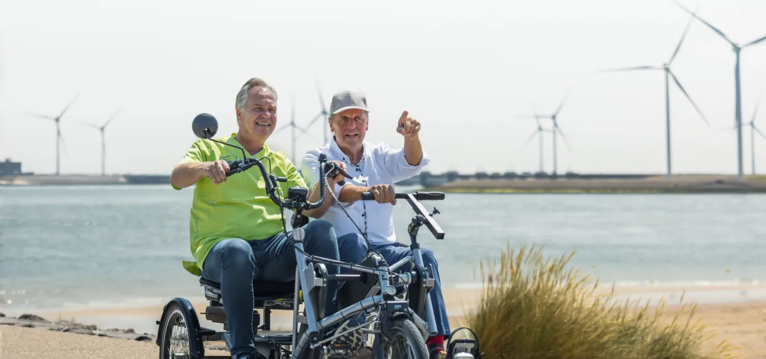 Fietsen medewerker met cliënt langs de zeedijk Allévo