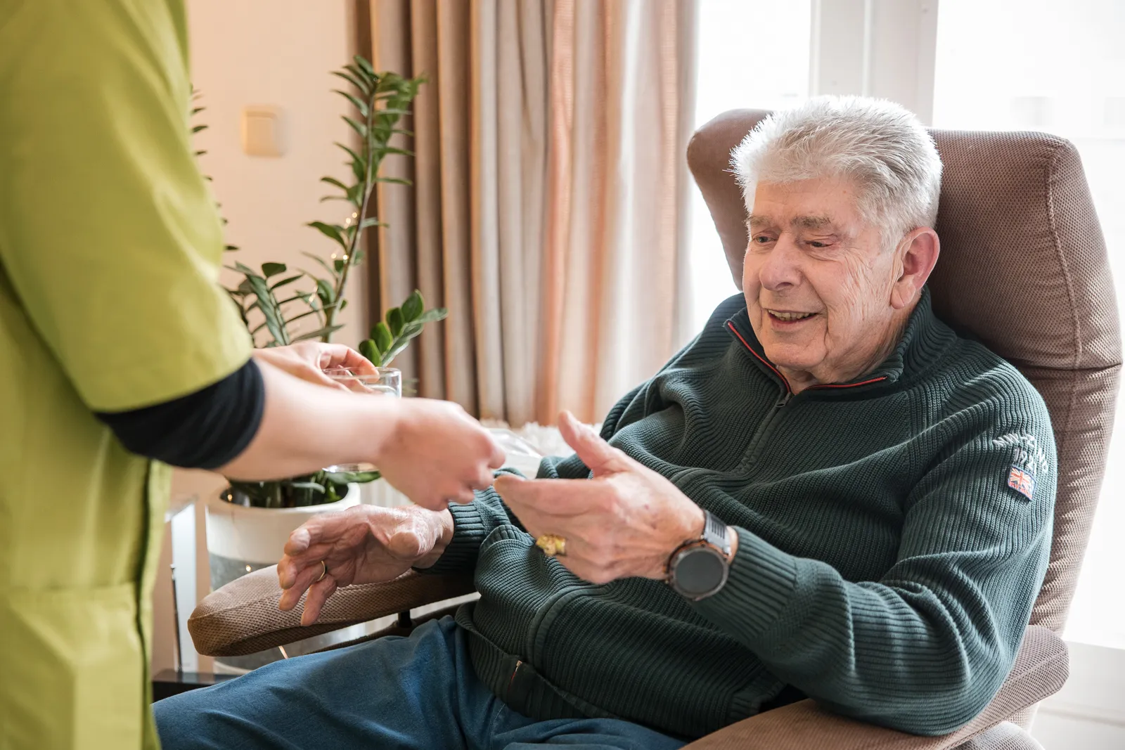 Medewerker rijkt medicatie aan aan cliënt.