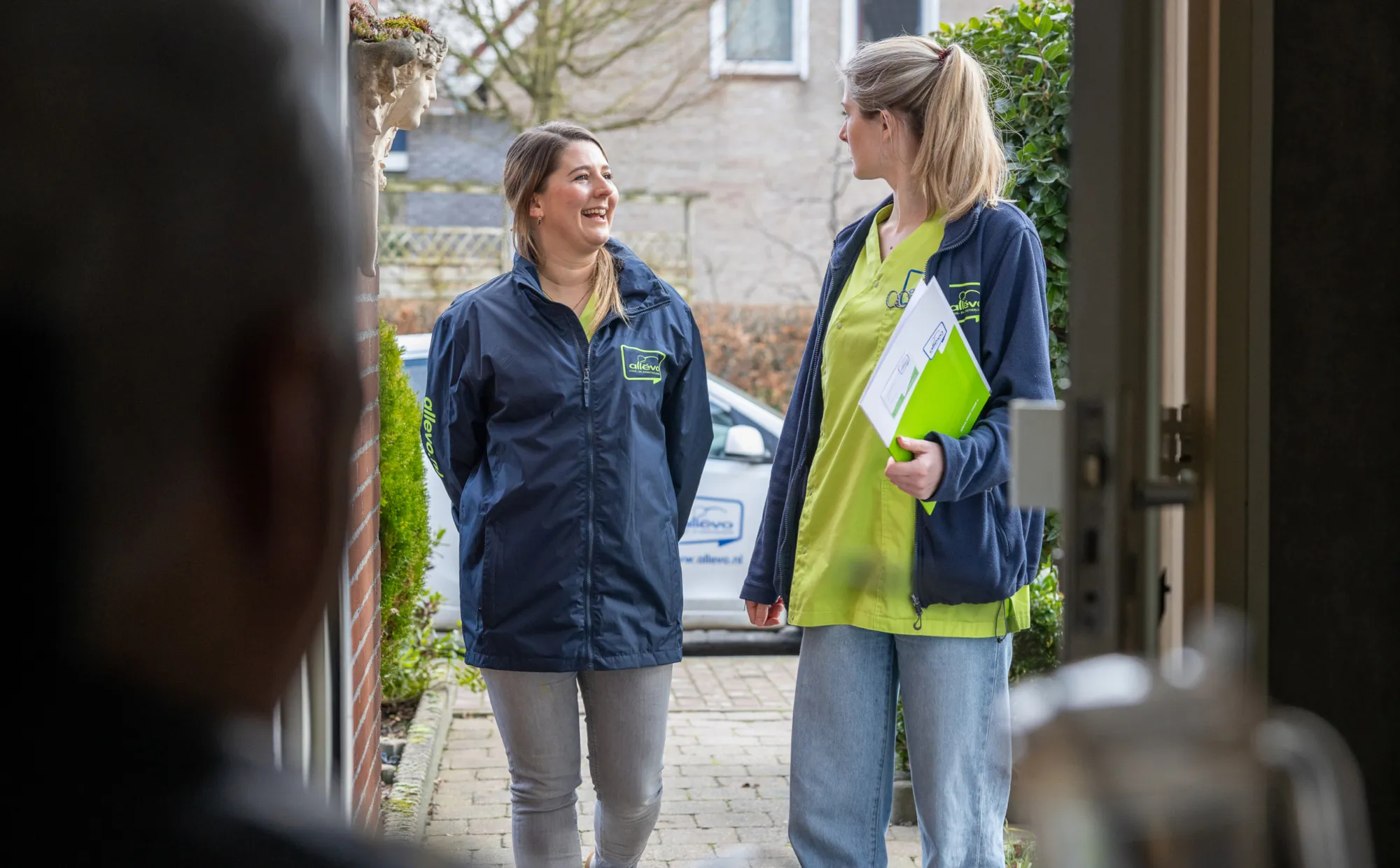Thuiszorg medewerkers kijken elkaar aan.