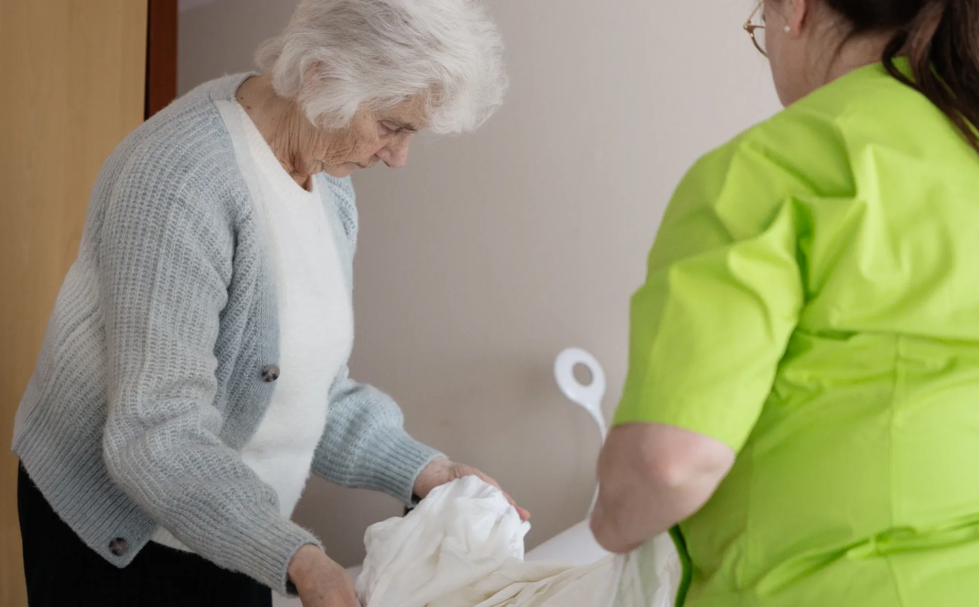 Medewerker Allévo en cliënt make samen bed op